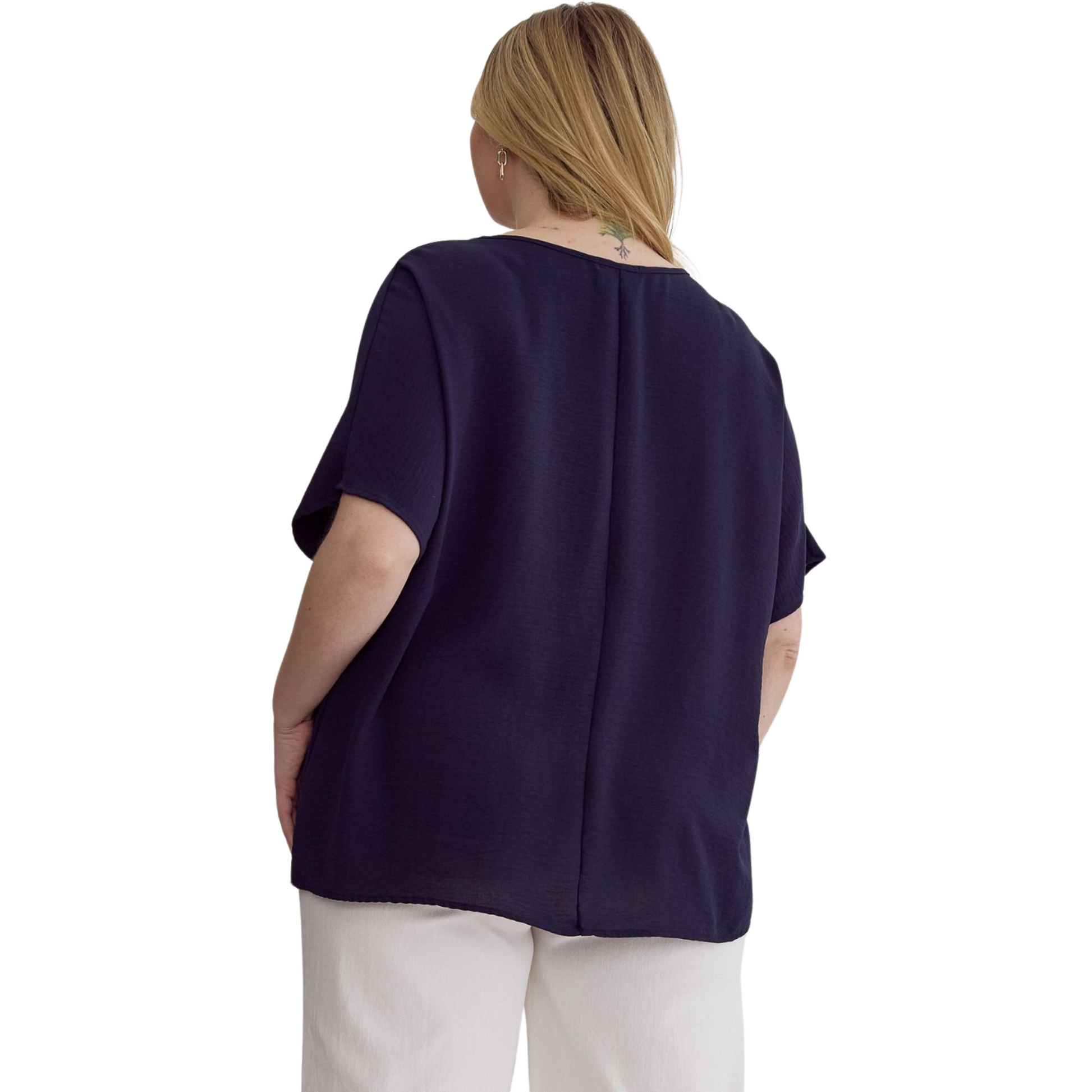 This solid v-neck top is perfect for those who prefer a little extra coverage. The asymmetrical rounded hem detail and semi-sheer fabric add a touch of style, while the lightweight woven material keeps you comfortable all day long. Available in navy and plus size.