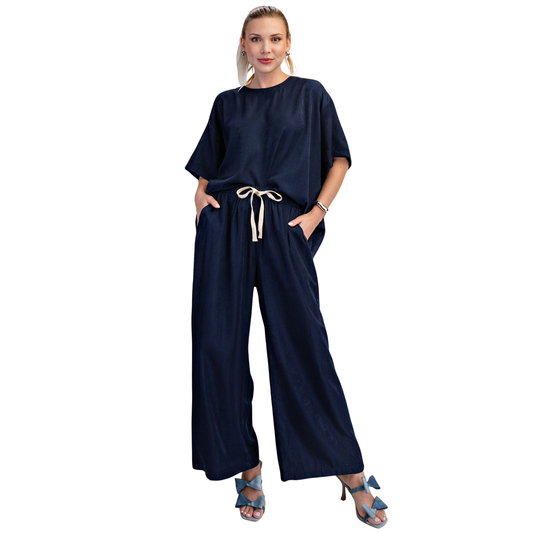 Elevate your everyday style with this chic Glam brand two-piece set. The oversized navy round neck top features comfortable short sleeves, perfectly paired with matching wide leg pants for an effortlessly polished look. Ideal for casual outings or relaxed workdays, this set combines comfort and contemporary fashion in one coordinated ensemble.