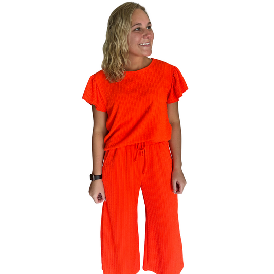 Elevate your summer style with our plus size Wide Leg Top and Bottom Set. Made with a vibrant coral color and featuring a comfortable drawstring and short sleeve top, this set is perfect for any occasion. Enjoy the breezy feel of the wide leg design while looking effortlessly chic.