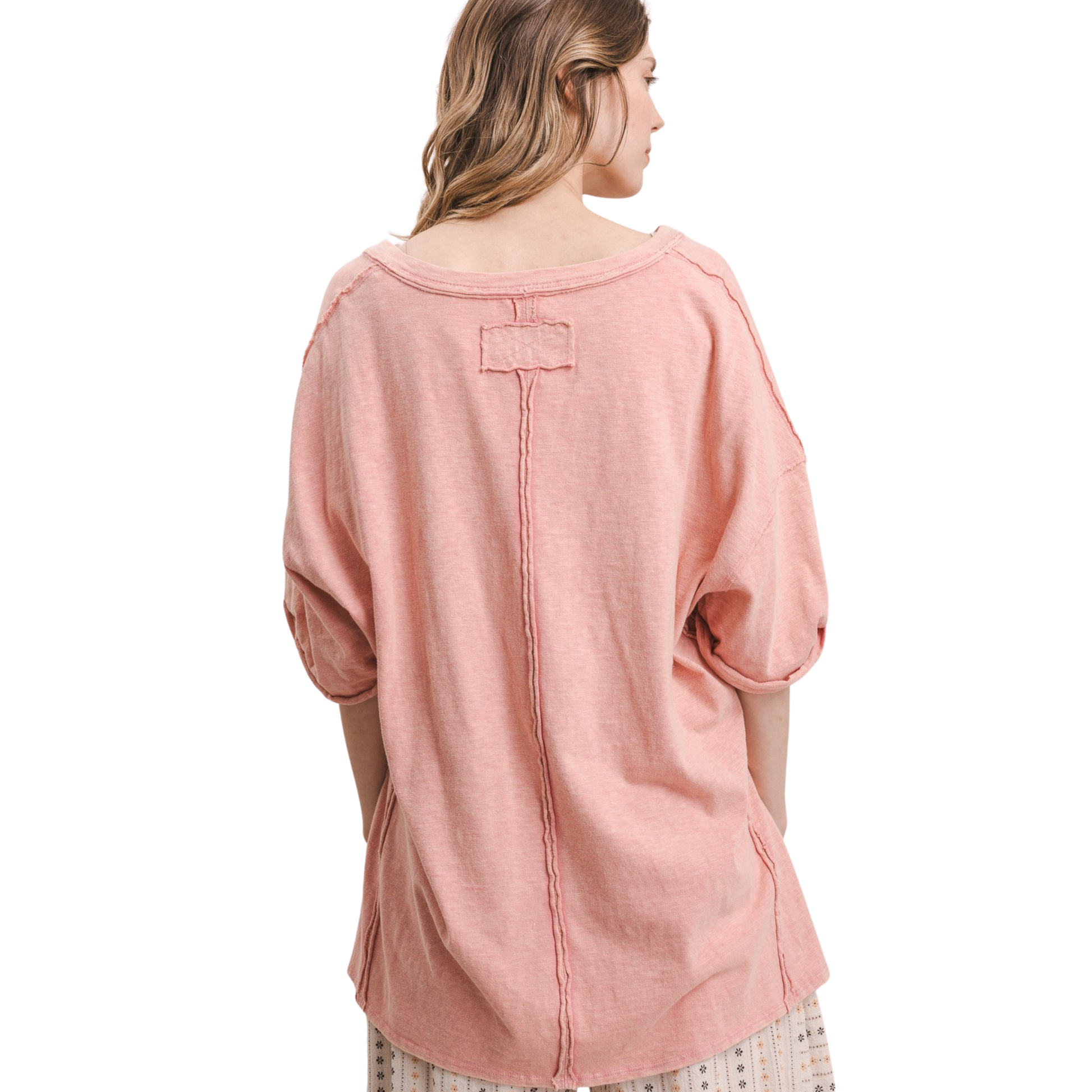Effortless style meets comfort in this oversized v-neck top from Blue Velvet. The relaxed silhouette drapes beautifully while the short sleeves keep things breezy and casual. Rendered in a soft pink coral hue, it's the perfect layering piece or standalone statement. Pair with your favorite jeans or linen pants for an understated, put-together look that works from day to night.