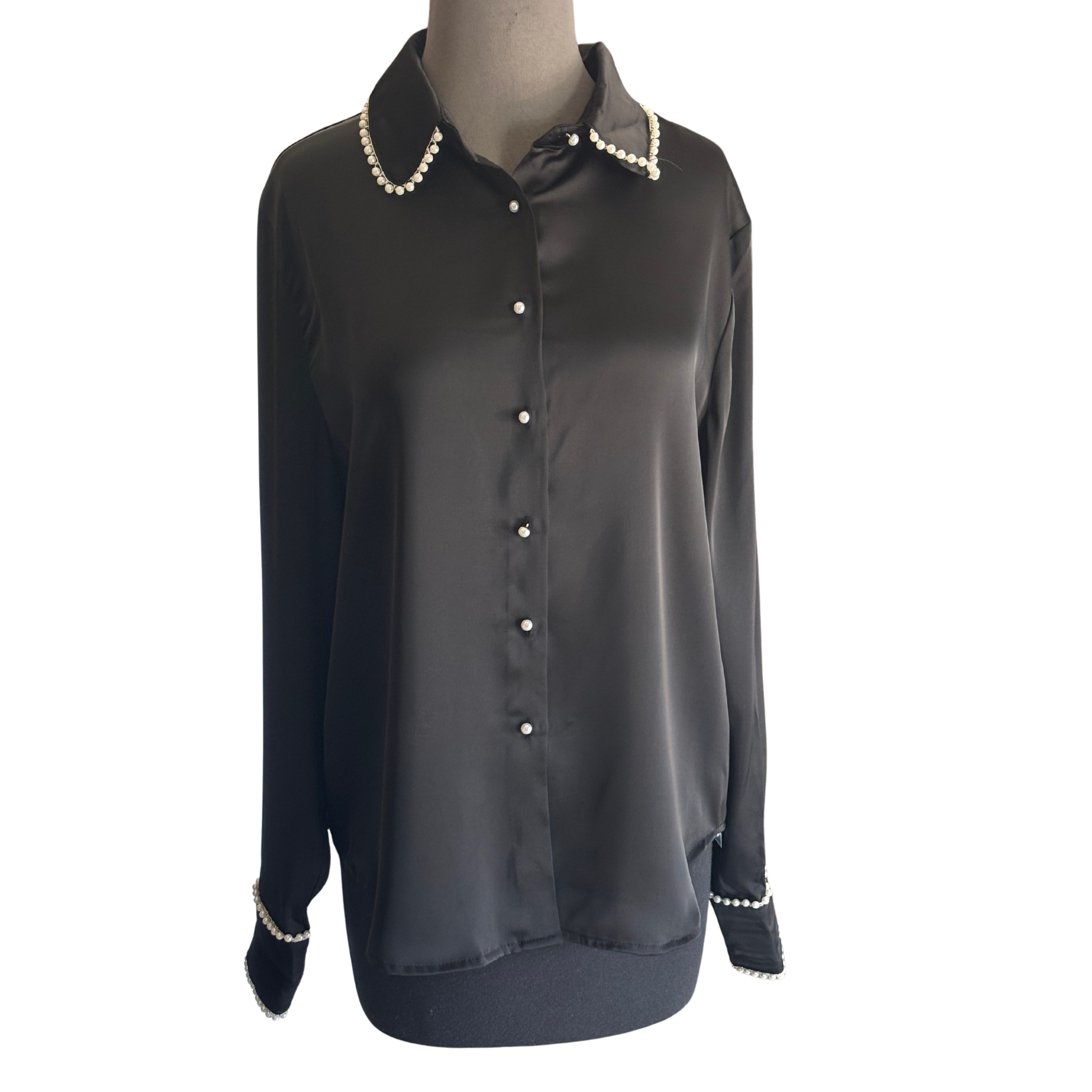 Elevate your wardrobe with the Pearl Trim Satin Top by D.ark. Crafted from smooth satin, this black long-sleeve blouse features elegant pearl trims and a refined pearl button-up front, combining timeless sophistication with modern luxury. Perfect for both professional settings and evening occasions, it offers a polished look that enhances your presence with subtle, exquisite details.