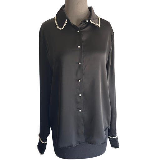 Elevate your wardrobe with the Pearl Trim Satin Top by D.ark. Crafted from smooth satin, this black long-sleeve blouse features elegant pearl trims and a refined pearl button-up front, combining timeless sophistication with modern luxury. Perfect for both professional settings and evening occasions, it offers a polished look that enhances your presence with subtle, exquisite details.