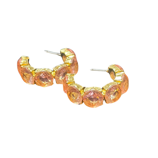 Crafted from durable gold, these Pink Rhinestone Hoop Earrings by Ruff-Skch offer a touch of elegance to any outfit. Large pink rhinestones add a pop of color, while the smaller hoops provide a delicate touch. Elevate your style with these high-quality earrings.