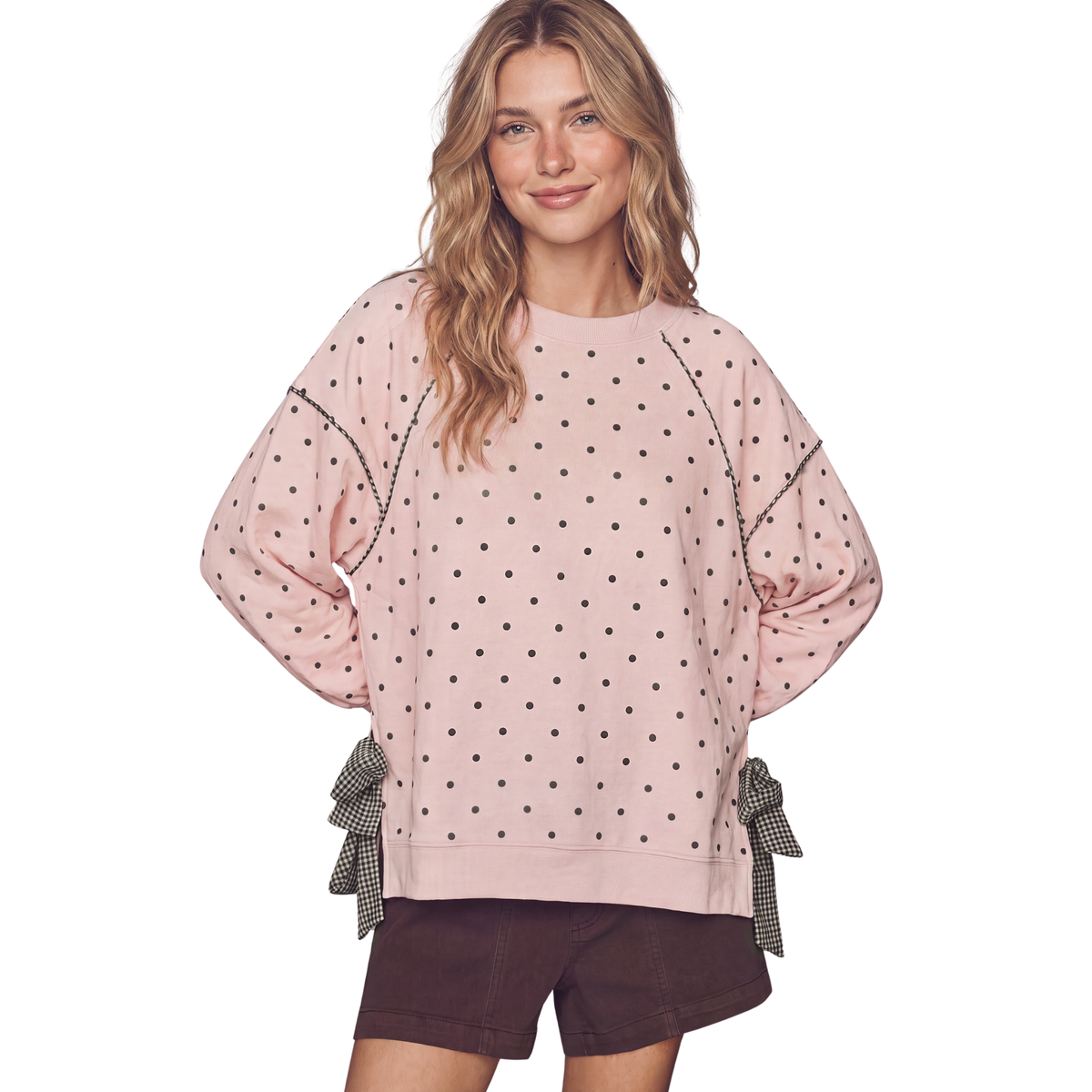 Polka Dot Sweatshirt from Peach Love combines playful style with cozy comfort. This long-sleeve sweatshirt features a charming mix of pink and green polka dots set against a soft gingham background, creating a fun, retro-inspired look. Adorable bow accents at the cuffs and neckline add an extra touch of personality. Perfect for casual wear, weekend outings, or layering during cooler months. Made with quality fabric for all-day comfort.