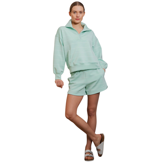 Your wardrobe needs this Modal Scuba Pullover and Skort Set by Rae Mode. The soft, breathable modal fabric offers comfort for all-day wear, while the half-zip design provides easy layering and temperature control. Featuring a fresh mint and cream striped pattern, this coordinated set pairs a relaxed pullover with a flattering skort for effortless style. Perfect for weekend outings, active days, or cozy lounging. The versatile color palette works seamlessly with your existing pieces.