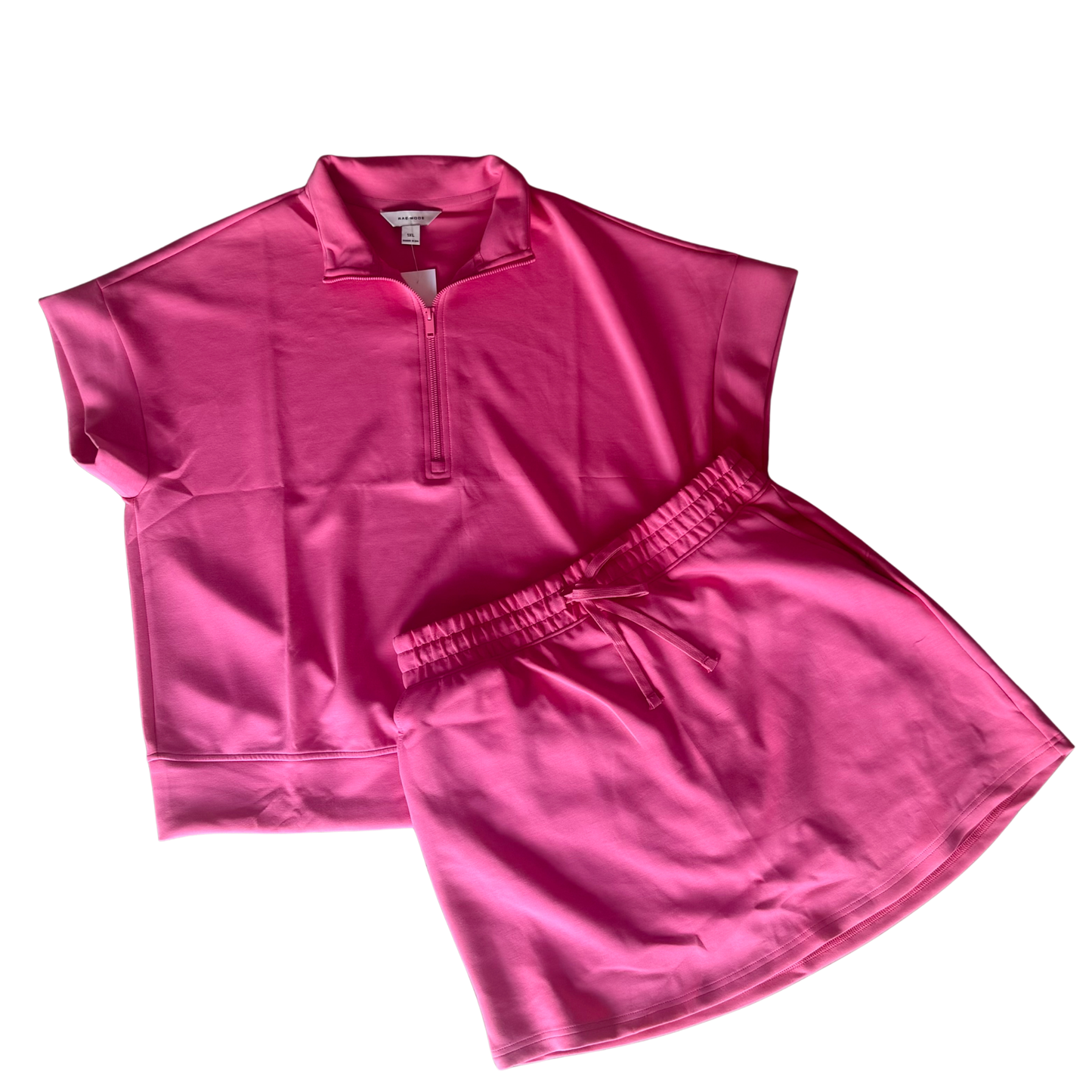 Elevate your casual wardrobe with this versatile Quarter Zip Short Sleeve Top and Skort Set by Rae Mode. The soft short sleeve top features a quarter zip design for easy layering and adjustable comfort, while the coordinating drawstring skort offers a flattering fit with functional pockets. Available in Brink Pink this set pairs effortlessly for weekend outings, active days, or relaxed everyday wear. The breathable fabric and thoughtful design make it a go-to.