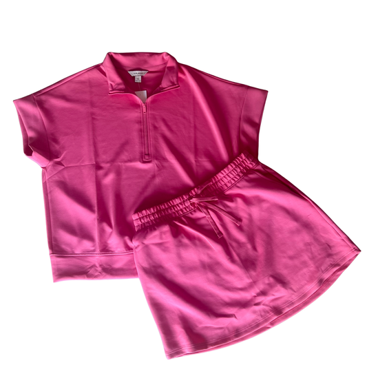 Elevate your casual wardrobe with this versatile Quarter Zip Short Sleeve Top and Skort Set by Rae Mode. The soft short sleeve top features a quarter zip design for easy layering and adjustable comfort, while the coordinating drawstring skort offers a flattering fit with functional pockets. Available in Brink Pink this set pairs effortlessly for weekend outings, active days, or relaxed everyday wear. The breathable fabric and thoughtful design make it a go-to.