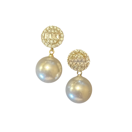 Discover sophisticated elegance with Perdido Gems' Rhinestone Dangle Earrings. These expertly designed pieces showcase radiant rhinestones set in warm gold, paired with subtle pearl accents that enhance their refined aesthetic. The dangling silhouette creates an effortless sense of movement and dimension, making them an ideal choice for discerning wearers seeking versatile luxury. 