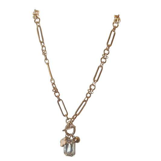 This ETE long necklace showcases a striking clover pendant finished in lustrous gold with intricate rhinestone detailing. The extended length offers versatile styling options, whether worn as a statement piece or layered with complementary jewelry. Crafted with precision, the rhinestone accents catch light beautifully, adding dimension and sophistication to any ensemble. An investment piece that balances elegance with enduring appeal.