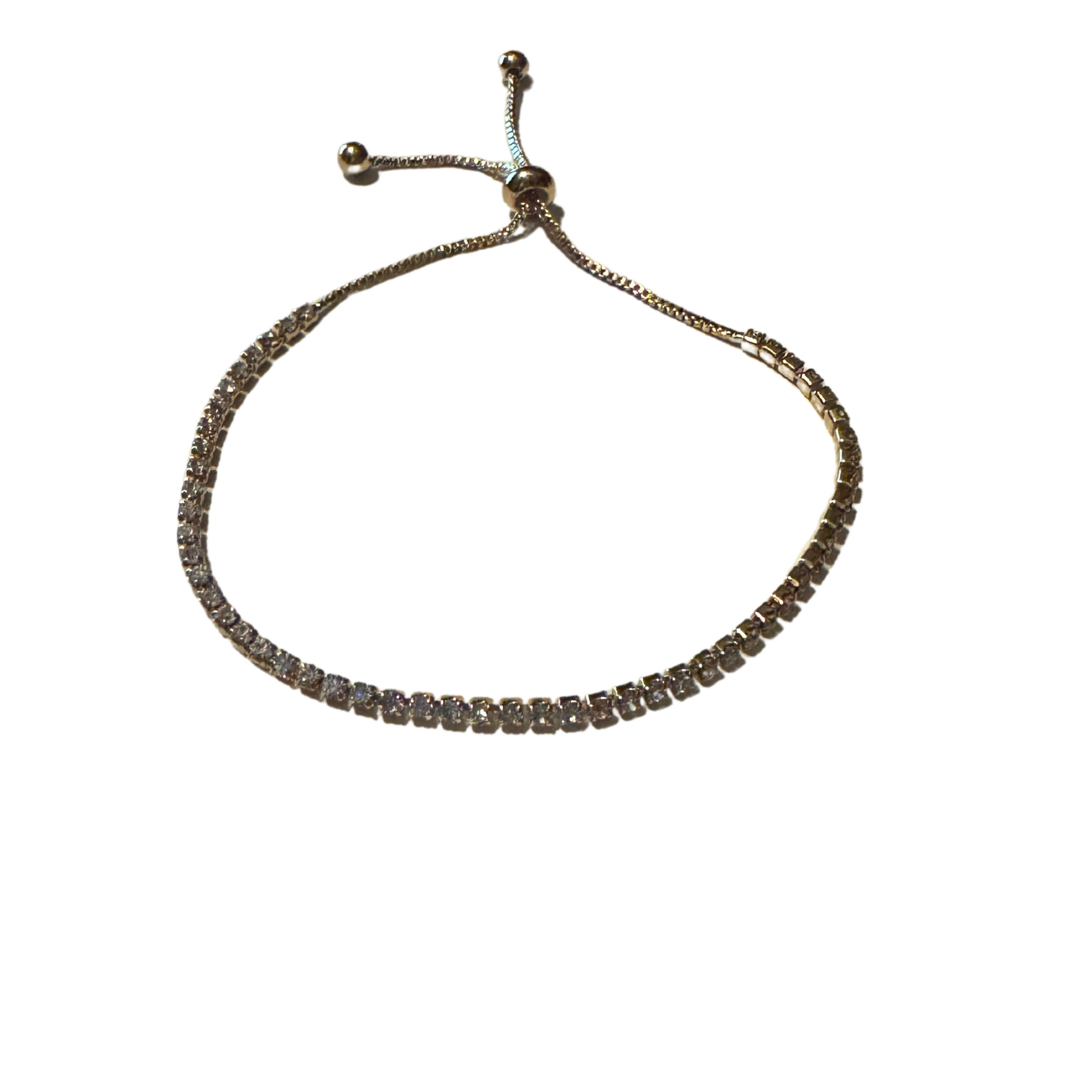 This elegant bracelet features stunning rhinestones and a luxurious gold finish. Its adjustable design allows for a perfect fit, making it the ideal accessory for any occasion. Elevate your style and add a touch of sophistication with this versatile tennis bracelet.