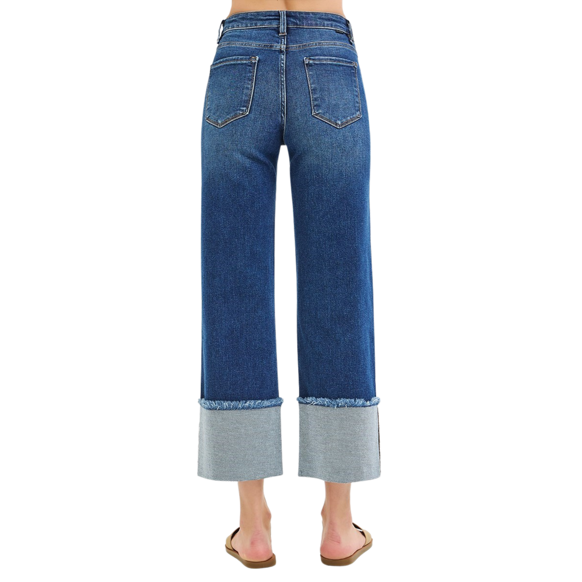 These Risen brand Mid Rise Cropped Wide Cuffed Jeans feature a dark wash and a wide leg with a wide cuff hem. Perfect for a trendy and stylish look, these jeans provide a comfortable fit and a fashionable edge. Upgrade your wardrobe with these must-have cropped jeans.