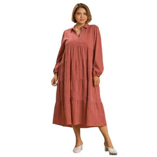 This Textured Tiered Maxi Dress offers a modern look with a split neck, long sleeves, and a textured tiered skirt. This Rose Clay color dress is sure to make a statement with its timeless style. With a perfect blend of fashion and comfort, this dress is perfect for any occasion.