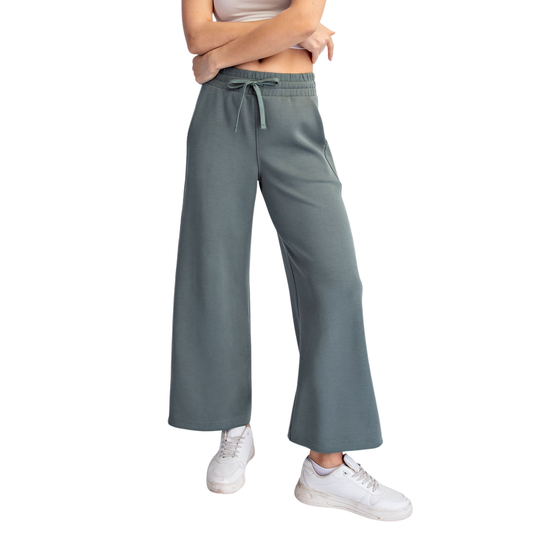 Elevate your casual wardrobe with these Modal Scuba Wide Leg Pants from Rae Mode. Crafted in a soft, breathable modal fabric, these cropped trousers feature a comfortable elastic waistband and adjustable drawstring for a customizable fit. The wide-leg silhouette offers a relaxed, flattering cut perfect for everyday wear. Available in a sophisticated sage green shade that pairs effortlessly with any outfit. Ideal for lounging, running errands, or dressing down your favorite tops.