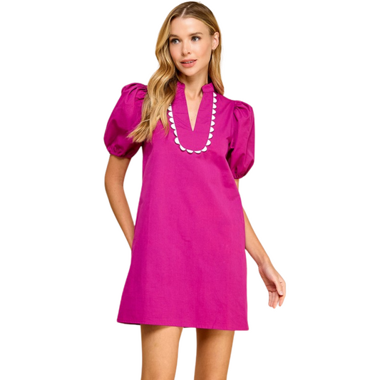 This elegant magenta dress features a split crew neckline, scalloped detailing, and short puff sleeves. With convenient side pockets, it combines style and functionality for a sophisticated look. Perfect for any occasion.