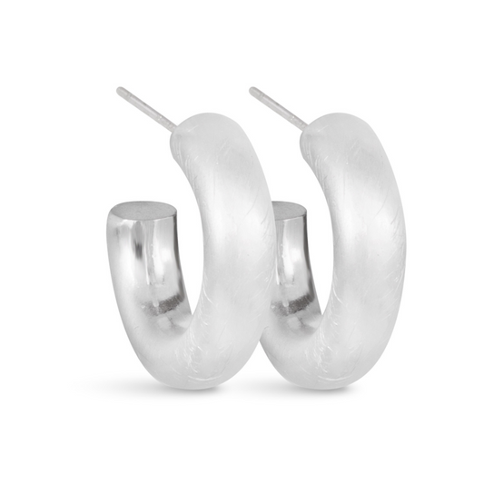 Introducing the Olivia Huggie Hoops, featuring a sleek matte finish and crafted with quality silver. These small hoops are perfect for adding a touch of elegance to any outfit. Elevate your style with the understated beauty of the Olivia Huggie Hoops.