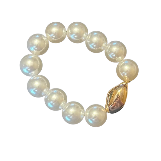 This ETE stretchy pearl bracelet combines classic sophistication with practical comfort. Genuine pearls are accented with delicate gold details, creating a refined aesthetic suitable for both everyday wear and special occasions. The elastic construction provides a secure, adjustable fit that accommodates various wrist sizes without compromising style. A versatile investment piece that brings timeless elegance to any jewelry collection.