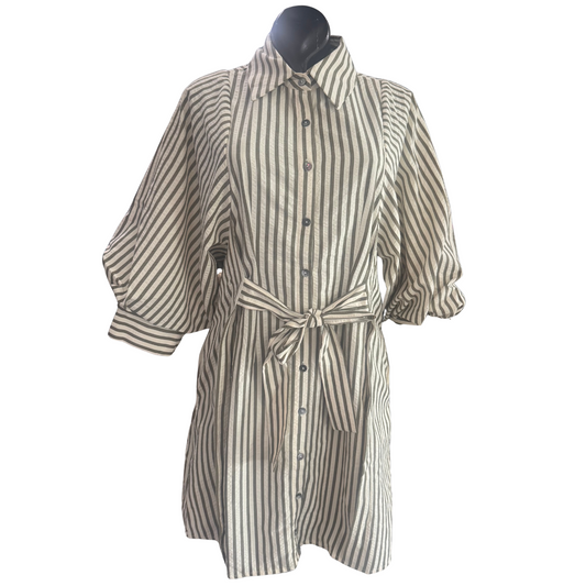 This olive-colored mini dress from Entro features a timeless striped pattern and a button-down front for effortless style. Designed with 3/4 length sleeves and a belted waist, it offers a flattering silhouette while maintaining comfort. Ideal for both casual and polished looks, this dress balances modern trends with classic appeal.