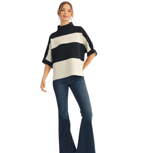 This Jodifl Drop Shoulder Sweater Top features a sophisticated black and white wide stripe pattern complemented by a mock neck for a modern touch. The 3/4 length sleeves balance style and comfort, making it ideal for transitional weather. Its relaxed drop shoulder design ensures an effortless fit, perfect for layering or standing out on its own.