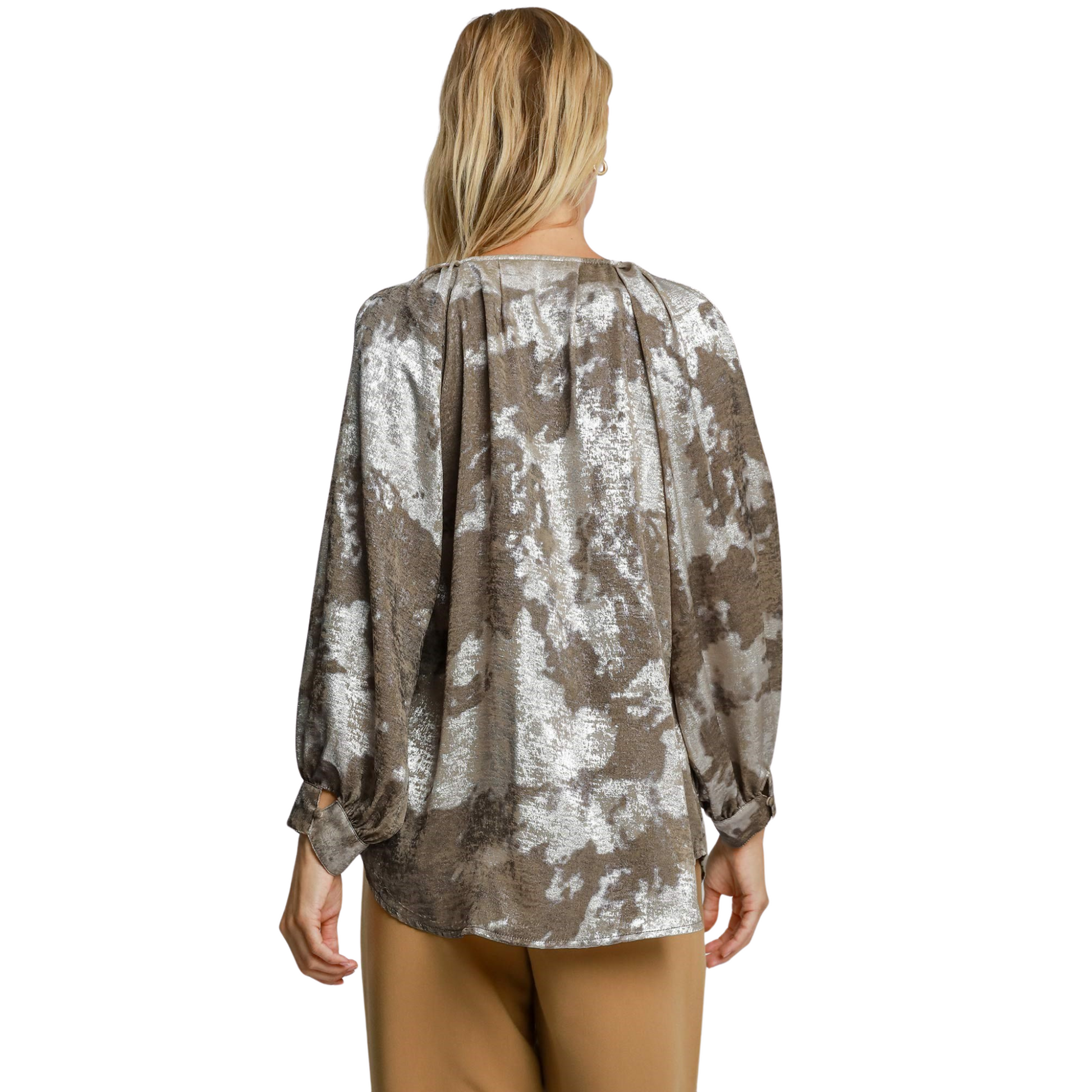 Expertly crafted by Umgee, this Metallic V-Notched Top features a stunning taupe color and abstract print, perfect for adding a touch of elegance to any ensemble. The v-neck and bubble sleeve design offer a flattering fit and comfortable wear. Elevate your wardrobe with this stylish, high-quality top.