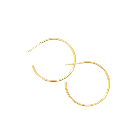 These medium hoop earrings from Perdido Gems showcase expertly designed gold construction with a delicate thin profile. The proportionate size offers substantial visual impact without excess weight, making them ideal for extended wear. Their classic circular form works harmoniously with various face shapes and personal aesthetics, while the quality gold finish resists tarnishing. A sophisticated staple that bridges casual and formal wardrobes with effortless versatility.