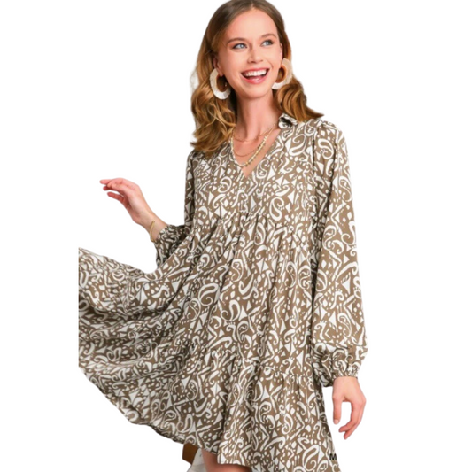 This Printed Long Sleeve Mini Dress features a two-tone print with elegant tiered layers. It has long sleeves and a collared neckline, all in a rich mocha color. It's the perfect balance of style and comfort, making it ideal for day-to-night wear.