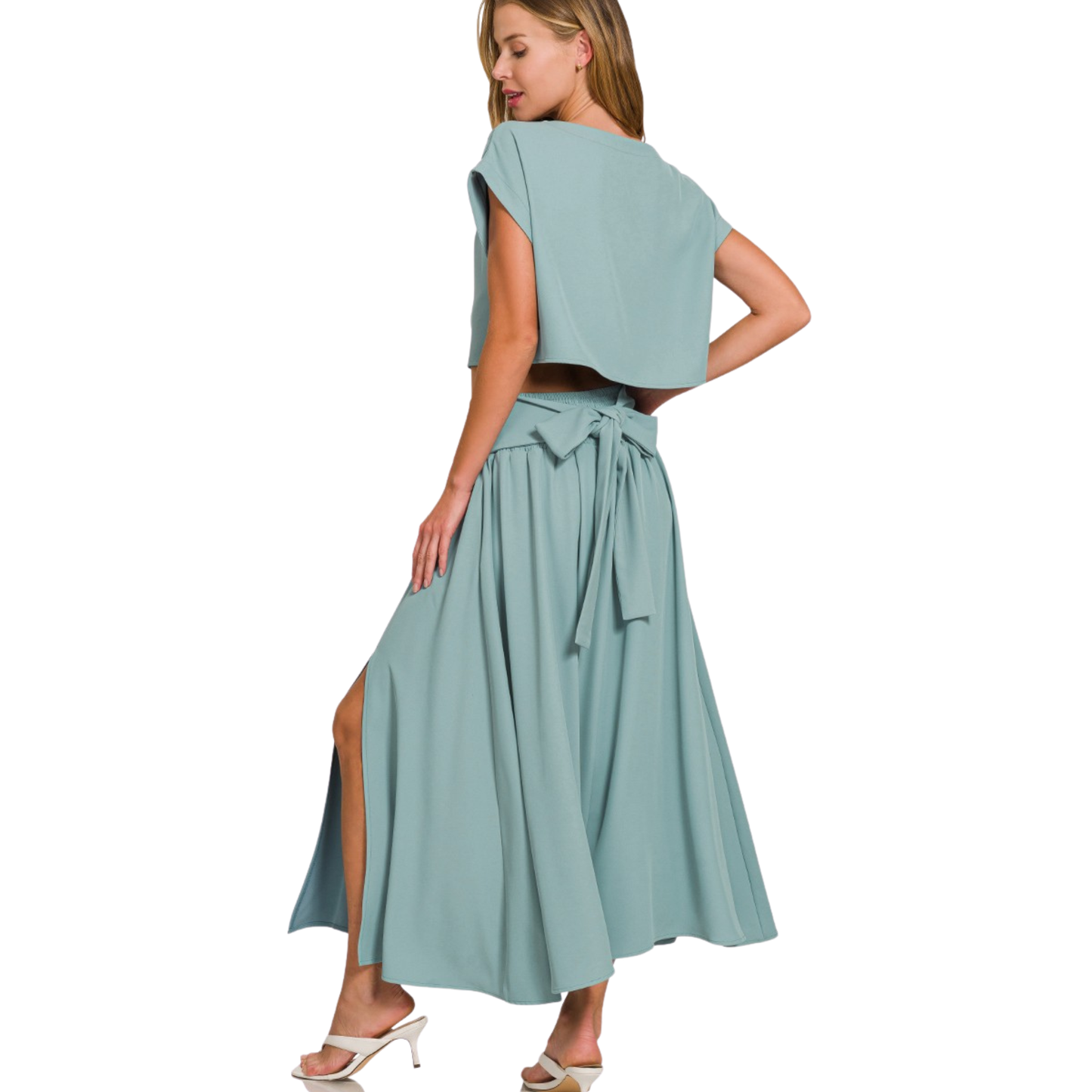 Elevate your casual wardrobe with this versatile Zenana set featuring a blue-grey cropped tee paired with a flowing maxi skirt. The short-sleeve tee offers effortless comfort, while the maxi skirt's strategic slit provides movement and modern appeal. This combination strikes the perfect balance between relaxed and refined, making it ideal for layering or wearing as a complete look. The coordinated color palette ensures seamless styling, whether you're dressing down for everyday wear or elevating the set for