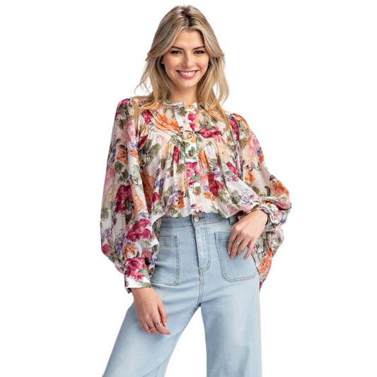 This vintage floral printed blouse is a timeless addition to any wardrobe. The rounded neckline, button down front, and added pleats create a flattering and relaxed silhouette. With buttoned cuffs and a slightly bubbled sleeve effect, this blouse exudes both elegance and comfort.