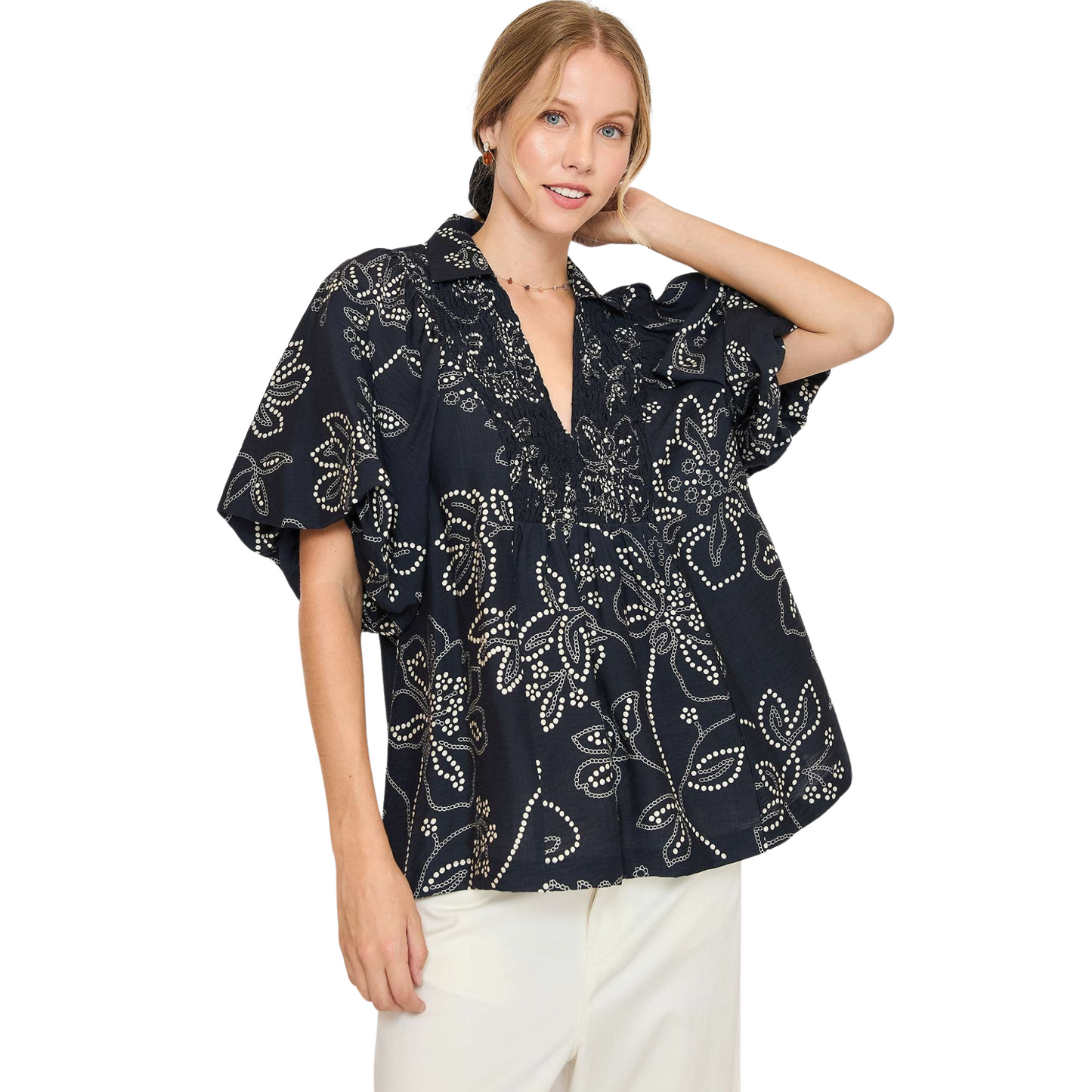 Introducing the Floral Print V-Neck Top from Umgee. This top features a black floral print, smocking detail, and a flattering v-neck. The short sleeves provide comfort and versatility, making it a perfect addition to your wardrobe. Embrace effortless style with this must-have piece.