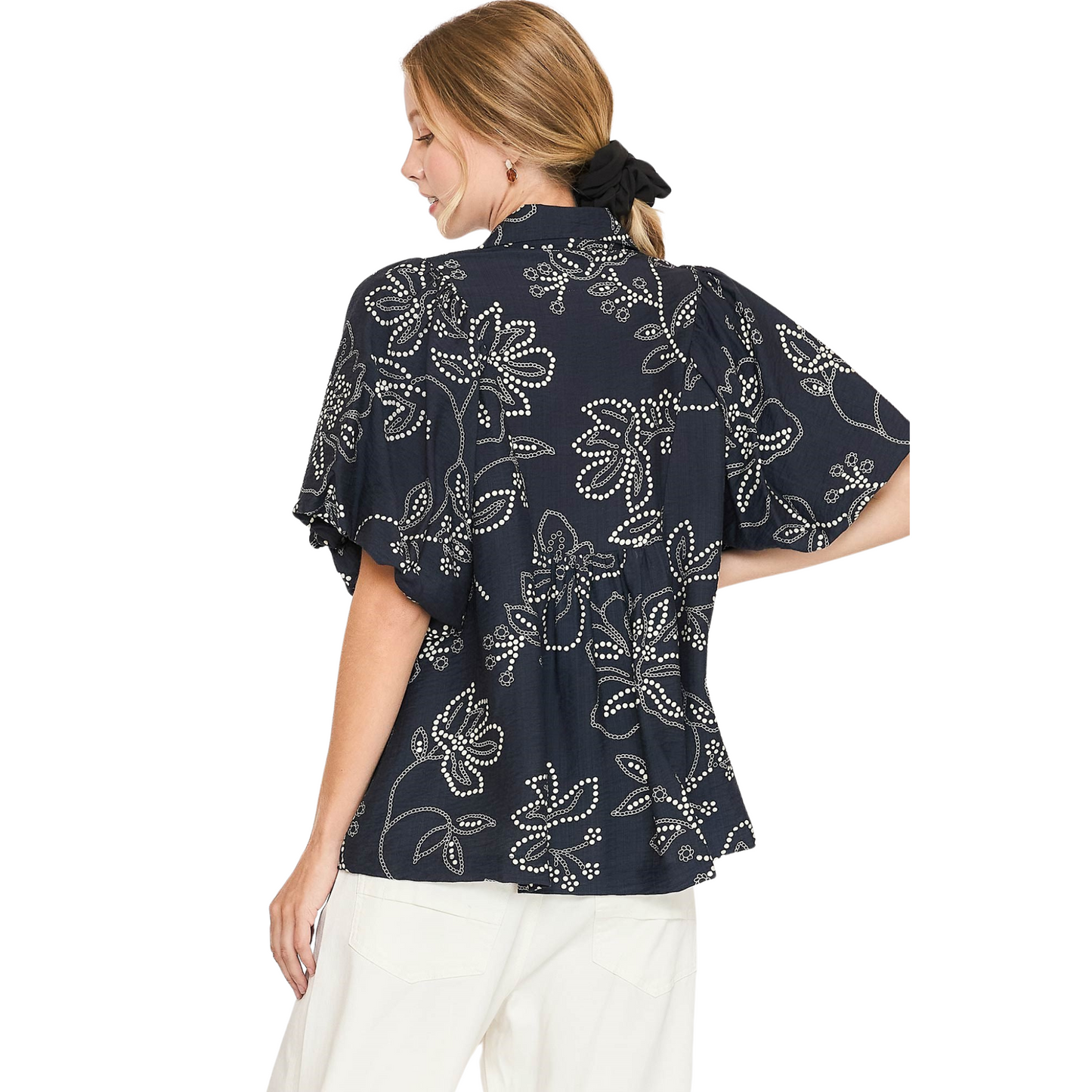 Introducing the Floral Print V-Neck Top from Umgee. This top features a black floral print, smocking detail, and a flattering v-neck. The short sleeves provide comfort and versatility, making it a perfect addition to your wardrobe. Embrace effortless style with this must-have piece.