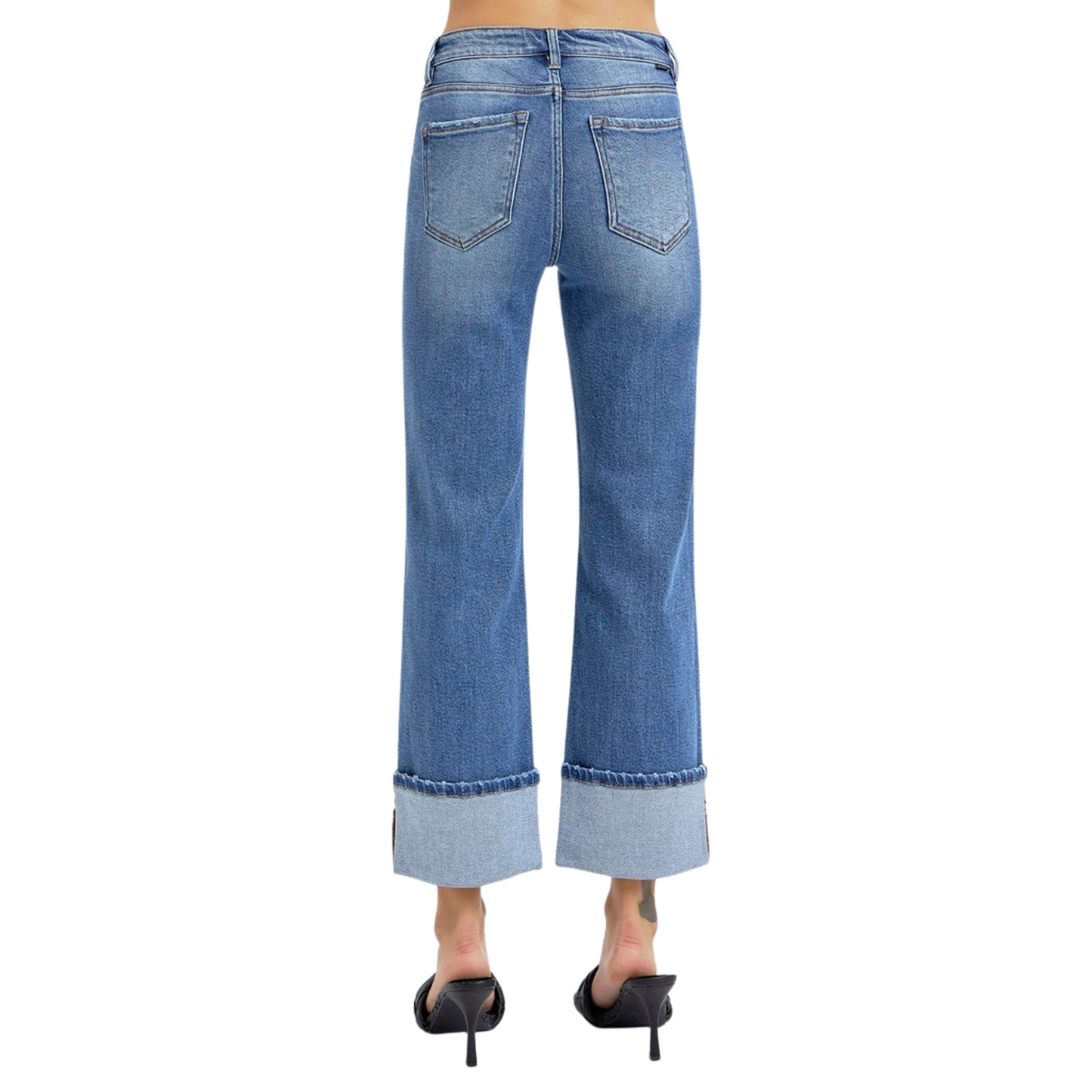 These High Rise Straight Wide Cuff Jeans from Risen offer a flattering medium wash and a wide cuff hem that adds a stylish touch at ankle length. Designed for a comfortable fit, they balance classic straight-leg tailoring with contemporary detailing, making them versatile for both casual and polished looks. The high-rise waist enhances posture and elongates the legs for a confident silhouette.
