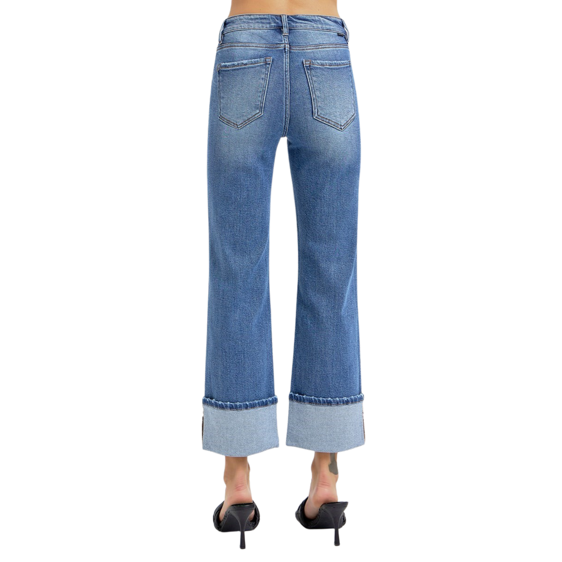 These High Rise Straight Wide Cuff Jeans from Risen offer a flattering medium wash and a wide cuff hem that adds a stylish touch at ankle length. Designed for a comfortable fit, they balance classic straight-leg tailoring with contemporary detailing, making them versatile for both casual and polished looks. The high-rise waist enhances posture and elongates the legs for a confident silhouette.